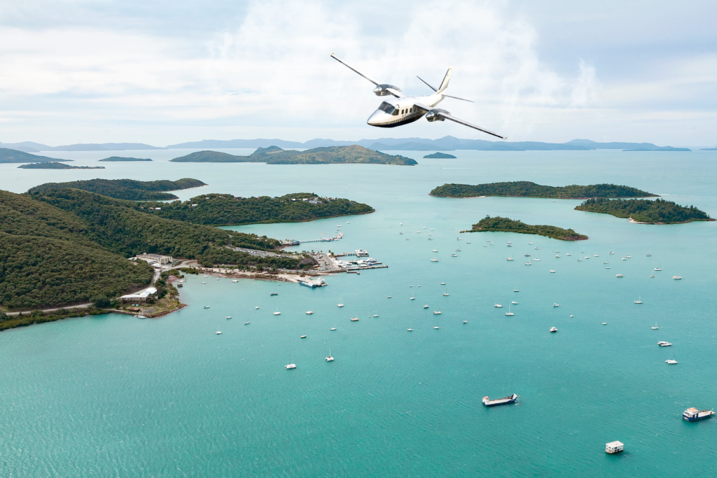 Aerial View Of Tropical Islands, Lush Hills, And A Helicopter Over Turquoise Waters.